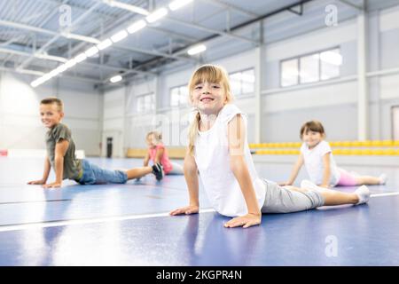 Girl exercising with elementary students at school sports court Stock Photo