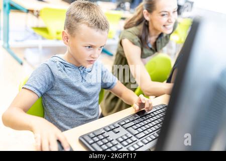 Concentrated boy using computer in class at school Stock Photo