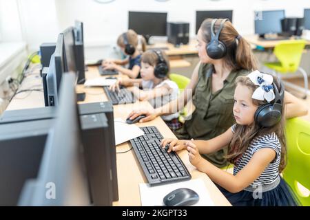 Girl studying through E-learning with teacher in class at school Stock Photo