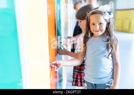 Smiling girl standing near lockers in school Stock Photo