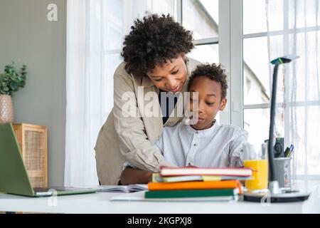 Mother helping son in homework at home Stock Photo