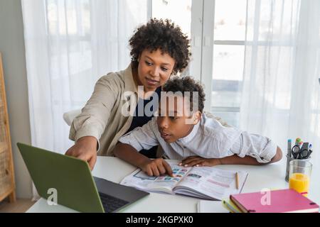 Mother and boy using laptop studying at home Stock Photo