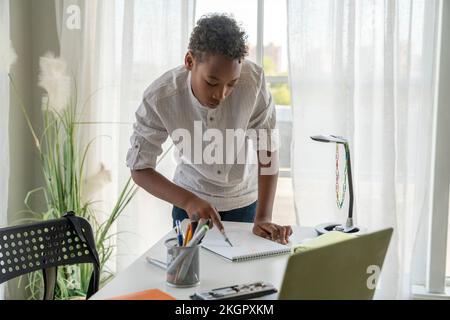 Boy doing geometry homework at table in home Stock Photo