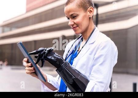 Smiling female doctor with artificial limb using tablet PC Stock Photo