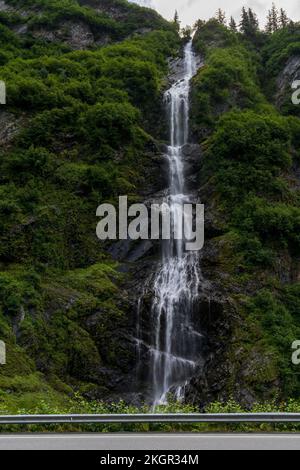 A vertical shot of Bridal Veil Falls surrounded by vegetation at Keystone Canyon in Alaska, USA Stock Photo