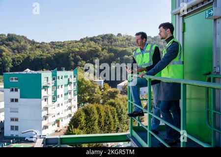 Engineers in reflective clothing standing at industrial plant Stock Photo