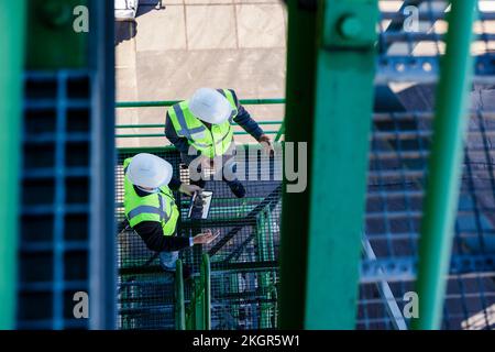 Engineers examining and having discussion at industrial plant Stock Photo