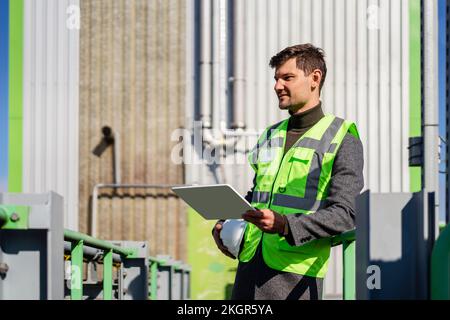 Engineer with tablet PC standing on sunny day Stock Photo