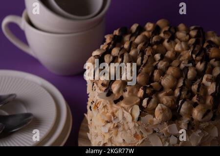 photo whole walnut cake and dinnerware side view on purple background Stock Photo