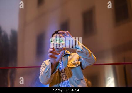 Mature man wearing smart glasses gesturing in front of building at night Stock Photo