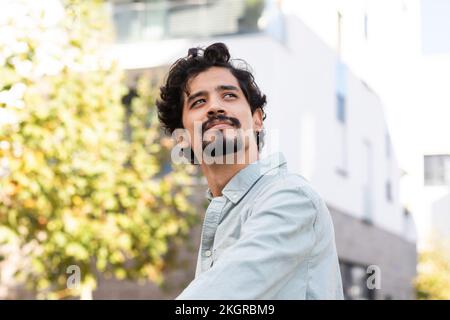 Thoughtful man with beard wearing shirt looking up Stock Photo