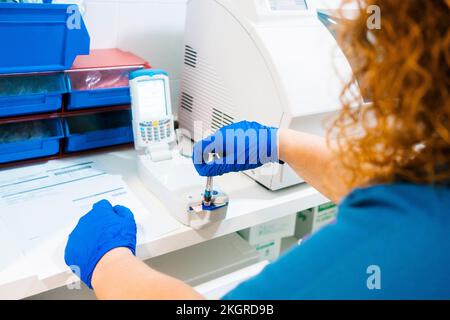 Mature nurse analyzing blood sample with equipment in laboratory Stock Photo