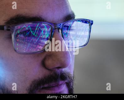 Trader wearing eyeglasses analyzing stock market data Stock Photo