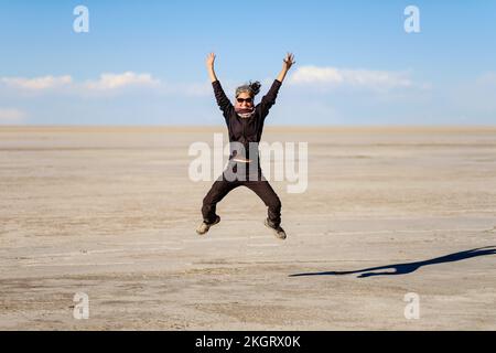 Happy woman jumping on the Salar de Uyuni (Uyuni Salt Flat), Potosi Department, Bolivia Stock Photo