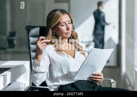 Businesswoman reading document in office Stock Photo
