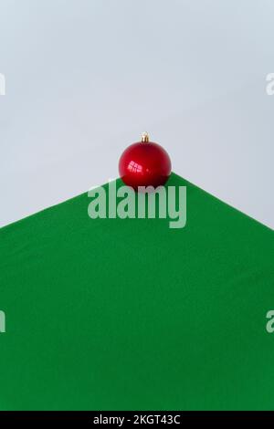 Red Christmas ornament on green velvet cloth over white background Stock Photo