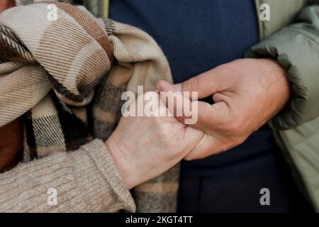 Couple wearing warm clothing holding hands Stock Photo