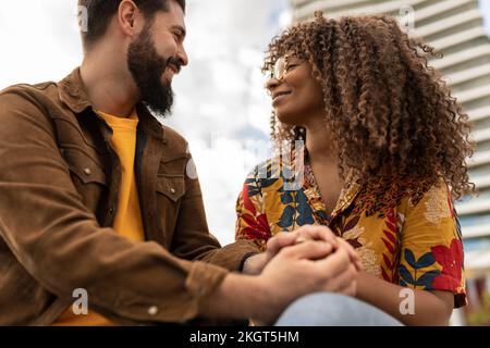 Happy young man holding hands of girlfriend Stock Photo