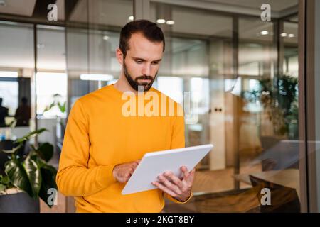 Young businessman using tablet PC in workplace Stock Photo