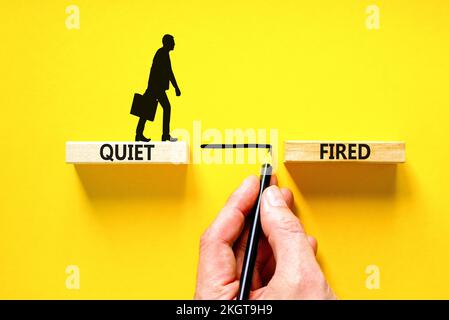 Quiet fired symbol. Concept words Quiet fired on wooden blocks. Beautiful yellow table yellow background. Businessman hand. Businessman icon. Business Stock Photo