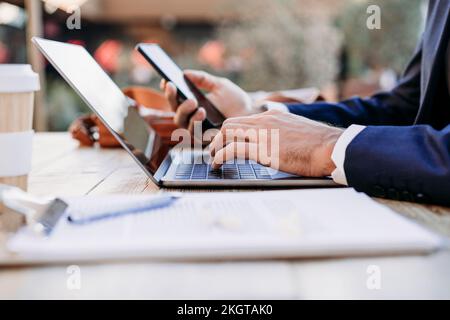 Hands of businessman working with wireless technologies at table Stock Photo