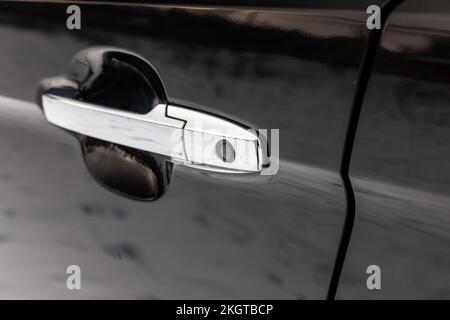 chrome car door handle with rubber keyless entry button to open the vehicle without looking for the key in the pockets wasting no time Stock Photo