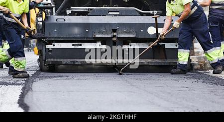 operators and road paving machines, freshly laid new asphalt Stock Photo
