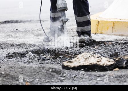Operator with hammer, drills the pavement to install the new asphalt Stock Photo