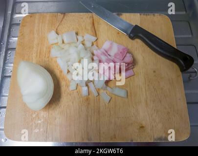 The sliced onion with the sliced ham on the chopping board ready to make salad, above view with the copy space. Stock Photo