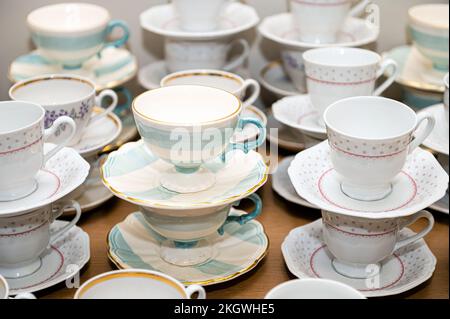 Close-up of coffee and tea cups with plates lined up on party table Stock Photo