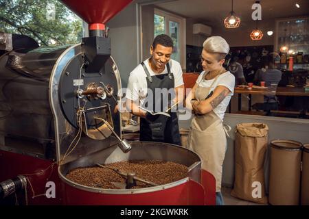 Two young roast masters engaged in work Stock Photo