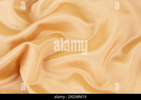 Smooth elegant gold color silk or satin luxury cloth texture as wedding background. Luxurious background design Stock Photo