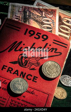 MICHELIN GUIDE 1950’s VINTAGE OLD FRENCH FRANCS CONCEPT Pre-Euro EU Retro style French Francs currency notes and coins on 1959 Michelin Guide France Stock Photo