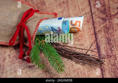 Jute sack with fir greenery and banknotes Stock Photo