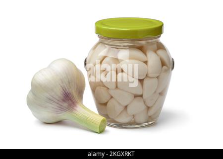 Pickled garlic in a glass jar and a fresh garlic bulb close up isolated on white background Stock Photo