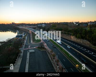 A drone view of a city skyline with highways near the water at sunrise in New Brunswick, Rutgers. Hub City, USA Stock Photo