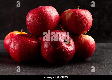 Fresh ripe red apples on a dark background, side view Stock Photo