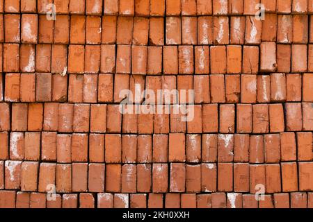 Textured background of fired bricks, handmade, irregular and cracked some on a street in Luang Prabang, Laos Stock Photo
