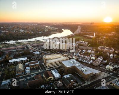 A drone view of a city skyline with buildings near the river at sunrise in New Brunswick, Rutgers, Hub City, USA Stock Photo