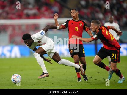 Canada's Alphonso Davies (left) and Belgium's Timothy Castagne (right) and Youri Tielemans battle for the ball during the FIFA World Cup Group F match at the Ahmad bin Ali Stadium, Al Rayyan. Picture date: Wednesday November 23, 2022. Stock Photo