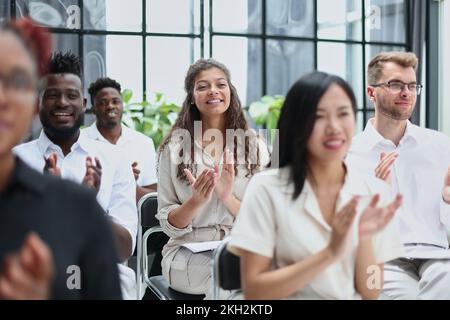 businesswoman applauding during seminar near interracial colleagues Stock Photo