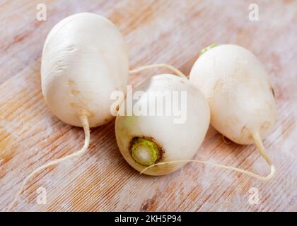 Whole white radishes on wooden surface Stock Photo