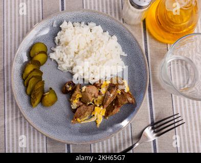 Scrambled eggs with rabbit liver, boiled rice and pickled cucumbers Stock Photo
