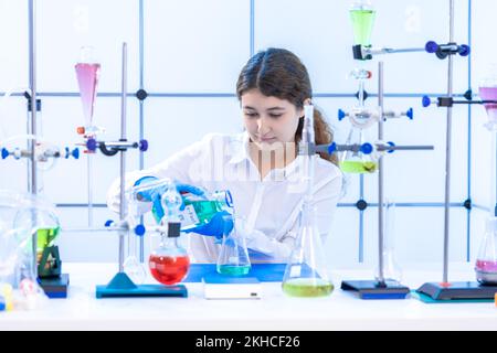 young adult female scientist conducts a chemical experiment in a hydrocarbon synthesis laboratory Stock Photo