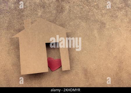 Little house shape cut out of paper and a heart on a canvas background Stock Photo