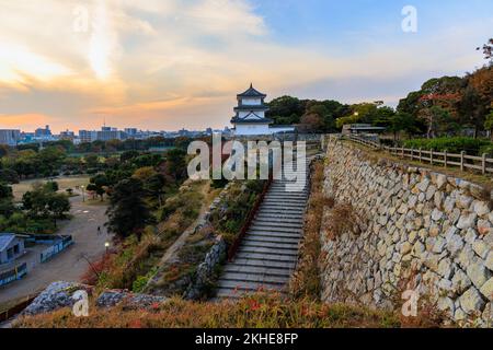 Stairs to castle lookout atop stone wall over city at sunset Stock Photo