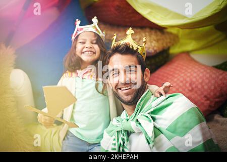 Shes the Queen of my heart. A cute little girl dressed up as a princess while playing at home with her dad. Stock Photo