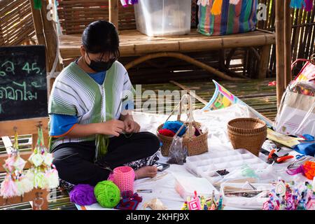 Karen ethnic working knitting yarn lanna style in handmade craft shop in oh poi local market for thai people and foreign traveler travel visit at Suan Stock Photo