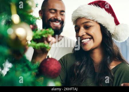 Christmas, tree and smile with a black couple decorating in the home together for the festive season. Love, celebration and holidays with a happy man Stock Photo
