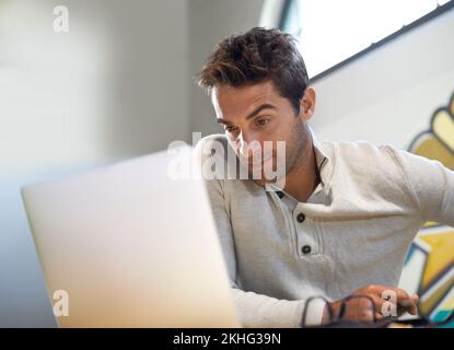 Focused on finding original ideas. A thoughtful young entrepreneur using his laptop. Stock Photo